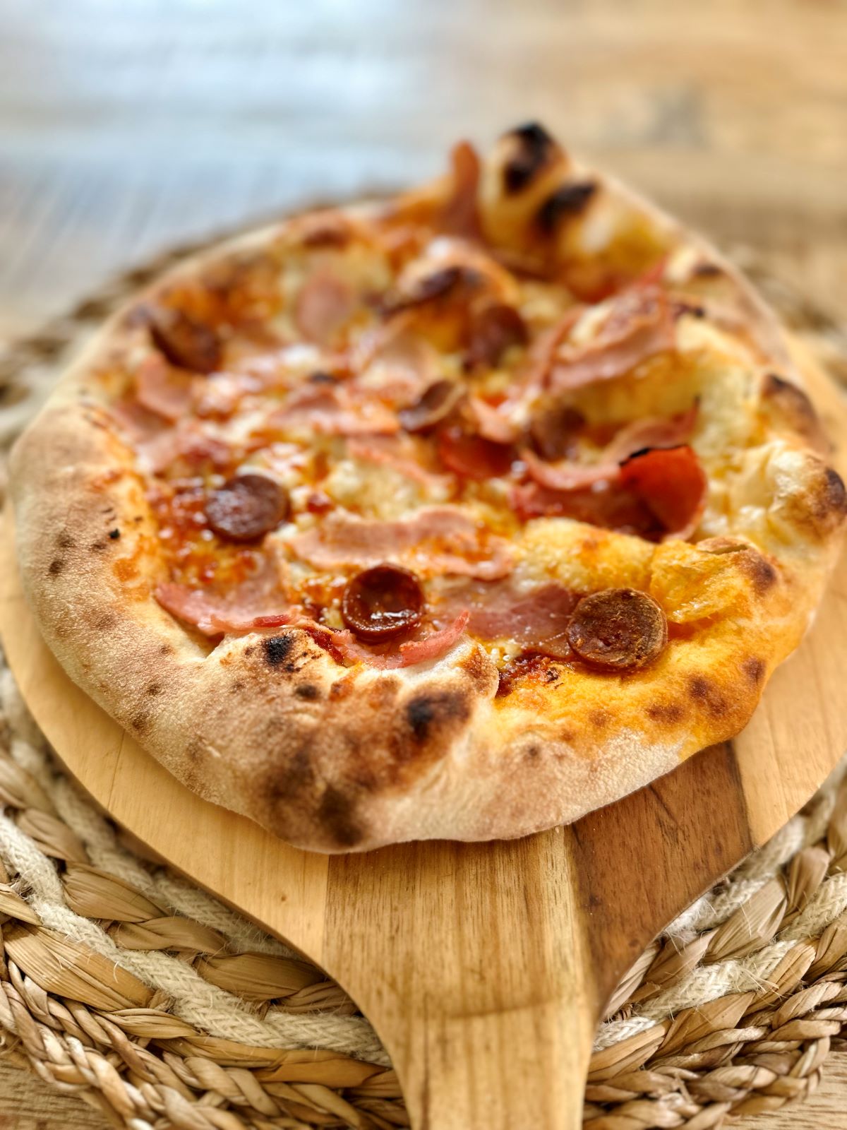 Pizza jambon chorizo cuite au four à pizza, avec une pâte napolitaine