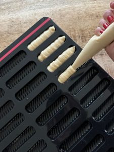 Avec une poche à douille garnir les empreintes du moule à madeleines